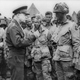 General Dwight D. Eisenhower, Supreme Commander of the Allied Expeditionary Forces in Europe, speaks with First Lieutenant Wallace C. Strobel and men of Company E, 2nd Battalion, 502nd Parachute Infantry Regiment on June 5, 1944. Strobel’s battalion was the first to drop into Normandy. Strobel survived both the Normandy invasion and the war. (US Army)